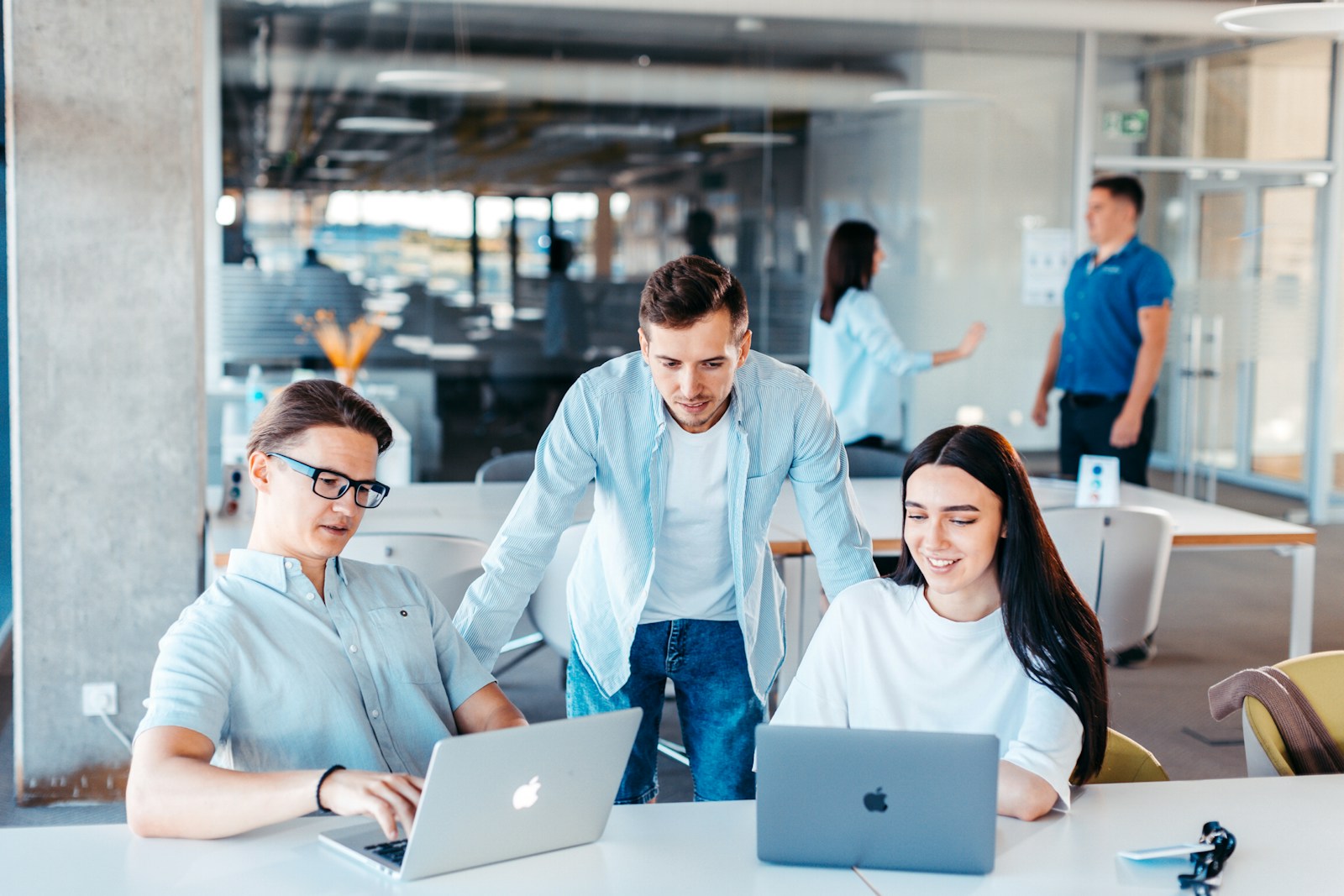 a group of people sitting around a table with laptops symbolizing good organizational health